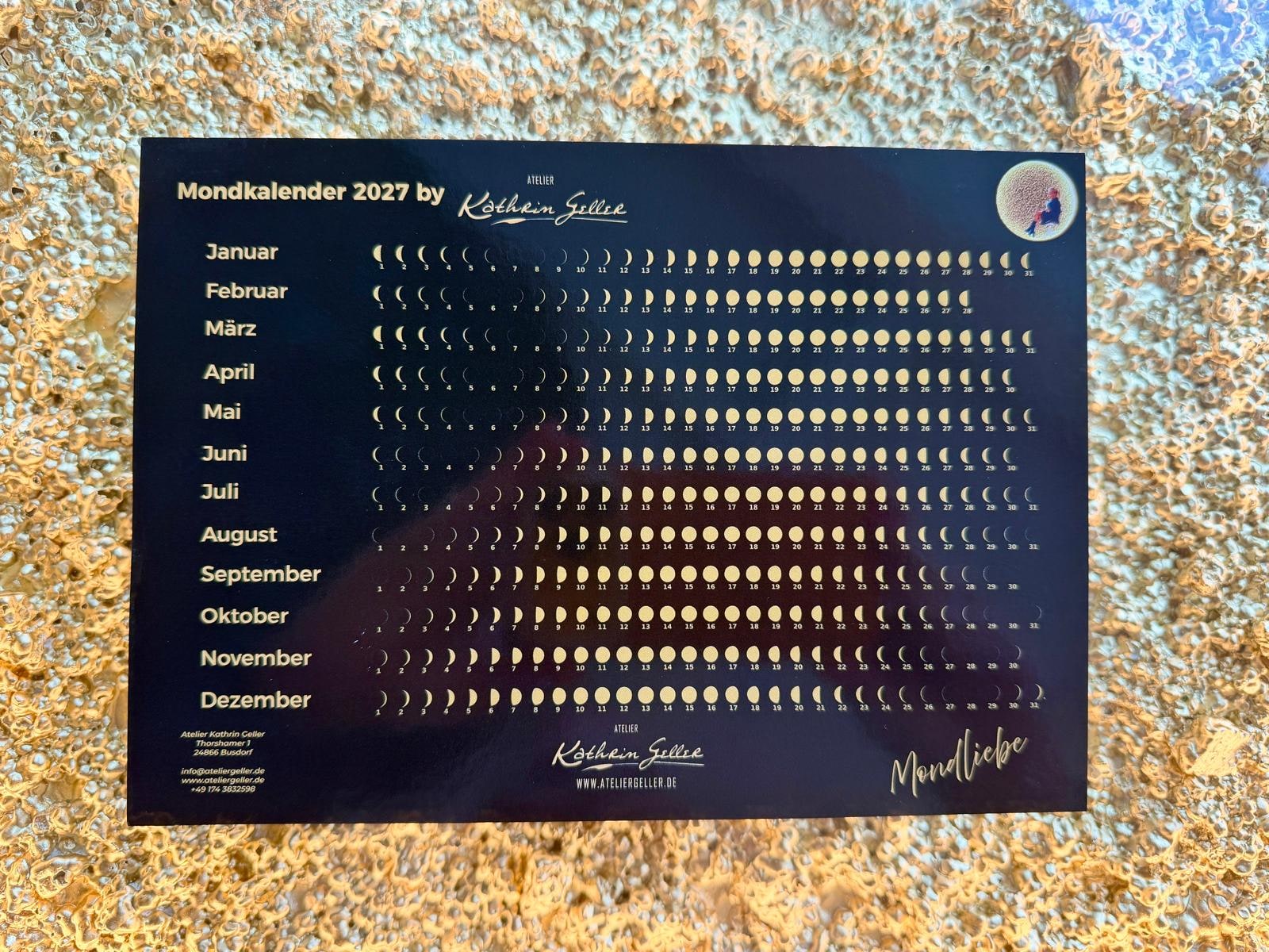 Mondkalender 2027 vom Atelier Kathrin Geller, zwölf Monatszeilen mit der Mondphase jedes Tages, hell auf dunklem Grund