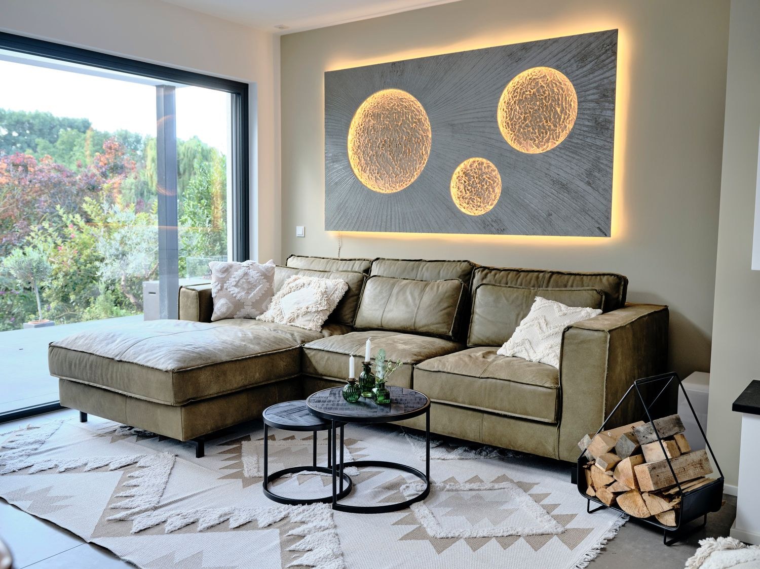 Das Lichtkunstwerk mit Monden über dem Sofa der Schölermanns, eingeschaltet