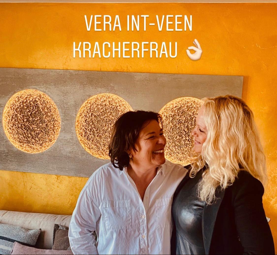 Vera Int-Veen und Kathrin Geller lachen vor dem Lichtkunstwerk mit drei Monden