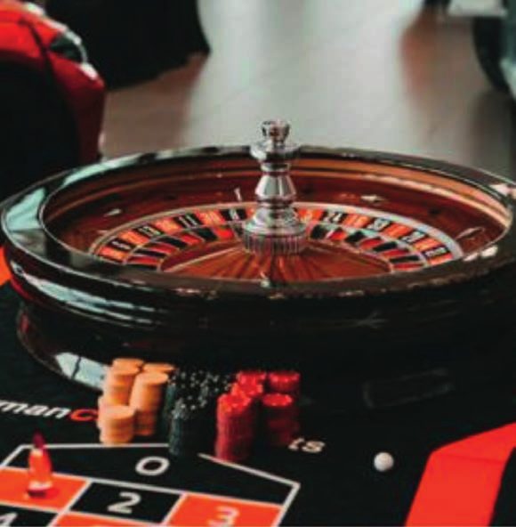 Roulettekessel und Jetons auf einem Spieltisch.