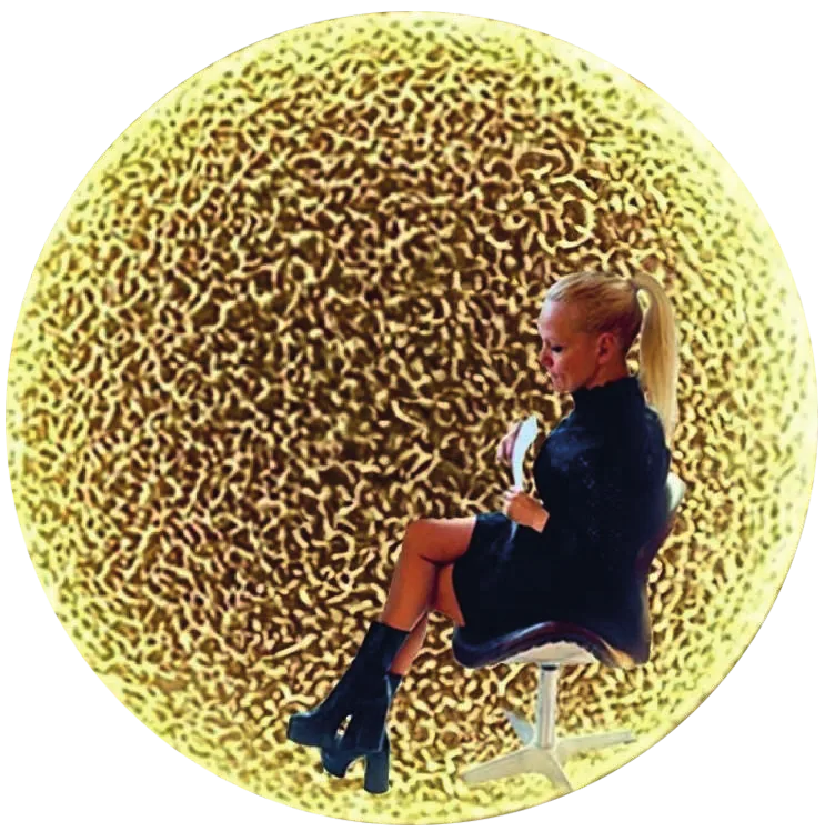 Kathrin Geller sitzt vor einem goldenen, beleuchteten Rundbild.