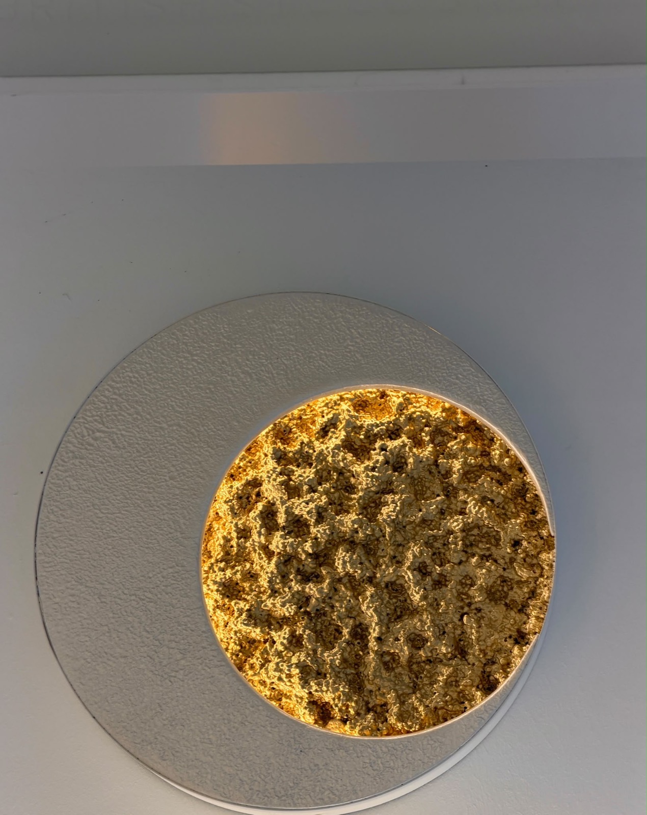 Mini-Mondharmonie Ø 50 cm, runde Platte Perlmuttweiß mit seitlich gesetztem, leuchtendem Mond Klassisch Gold an einer hellen Wand